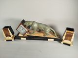 une statue de chat posée sur une table avec une horloge