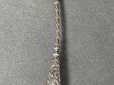 an old silver spoon with a gold spoon handle on a gray surface
