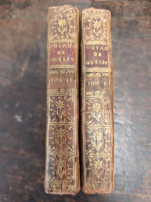 deux vieux livres posés l'un à côté de l'autre sur une table en bois