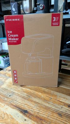 une boîte posée sur une table, dans laquelle se trouve une cafetière
