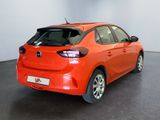 the rear end of an orange car in a showroom