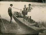 three men standing in a row boat on the water