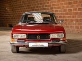 a red car parked in front of a brick wall