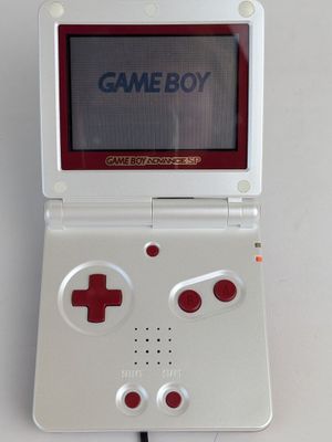 a game boy game console sitting on a white table