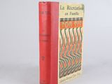 un vieux livre à la couverture rouge posé sur une table blanche