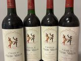 four bottles of red wine are lined up on a table