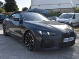 a black car parked in a parking lot next to other cars