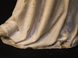 a statue of a woman sitting on a black surface