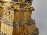 a gold statue of a man and a woman on a pedestal