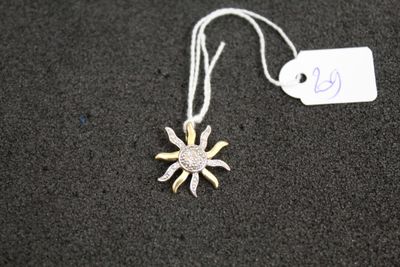 un collier en argent et en or orné d'un pendentif en forme de soleil