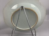 a white plate with a triangle on it on a stand