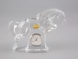 une figurine en verre représentant un cheval, sur laquelle est placée une horloge