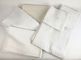 four white napkins are stacked on top of each other on a table