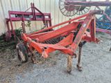 un tracteur rouge garé à côté d'un bâtiment