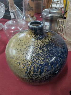 un vase bleu et jaune posé sur une table rouge