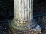 a statue of a man sitting on top of a stone pedestal