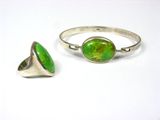 a close up of a ring and a ring with a green stone