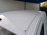 a white car with a blue roof and a blue awning