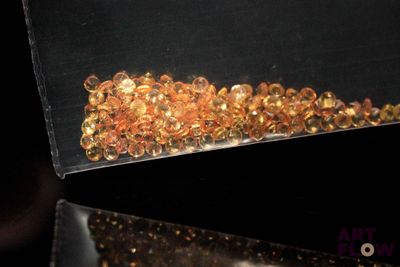 une boîte noire contenant un tas de perles dorées