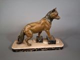 statue d'un chien posée sur un socle en marbre, sur fond gris