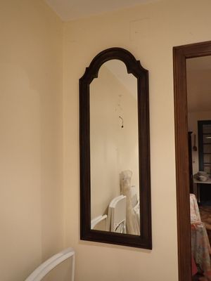 un miroir accroché au mur au-dessus d'une chaise