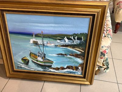 un tableau représentant un bateau dans l'eau, à côté d'un canapé