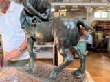 a man standing next to a statue of a horse