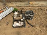 un boîtier électrique posé par terre à côté d'un tas de câbles