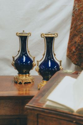 two blue vases sitting on a table next to an open book