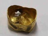 gros plan d'une bague en or sur une surface blanche