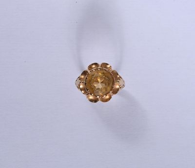 un gros plan d'une bague posée sur une surface blanche, avec une ombre