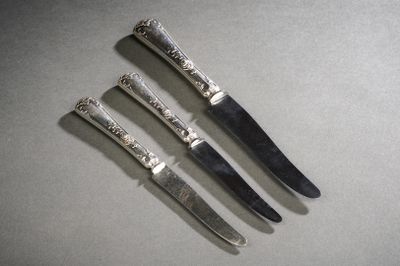 quatre couteaux sont alignés sur une table