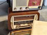several old radio ' s stacked on top of each other in a room