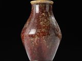 a red vase sitting on top of a white shelf