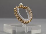 gold plated ring with a pearl bead on a clear acrylic stand
