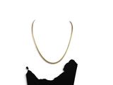 necklace with a gold chain and a black dress on a white background