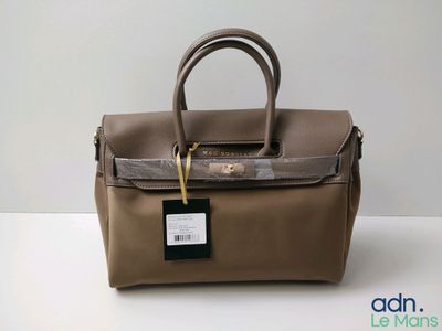 an image of a brown leather handbag with a tag on it