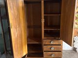 a wooden cabinet with two doors open in a room