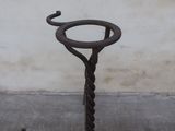 a metal pole with a hook on it near a wall