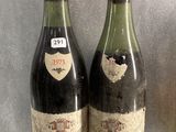 two bottles of wine sitting on top of a glass shelf