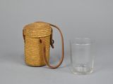 a small wicker bag and a glass on the table