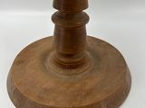 a wooden stand with a candle on it on a white surface