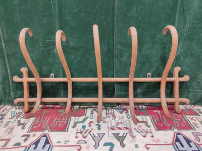 a wooden rack that has a bunch of hooks on it