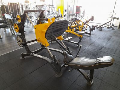 des appareils de fitness jaunes et noirs dans une salle de sport au sol noir