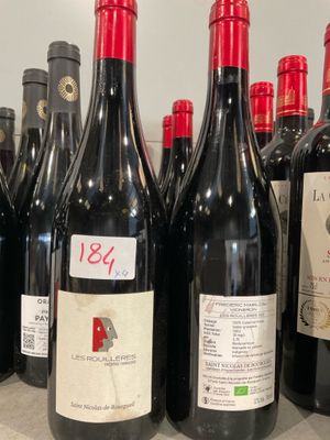 de nombreuses bouteilles de vin rouge alignées sur le comptoir