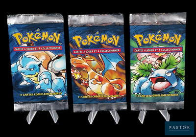 trois paquets de cartes Pokémon exposés sur un fond noir