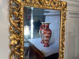 un cadre doré sur lequel figure l'image d'un vase