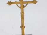 an old wooden cross on a black stand on a white surface