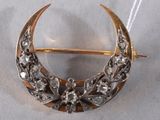 an image of a gold and silver crescent broochle with flowers