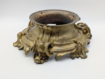a gold vase that is sitting on a white surface